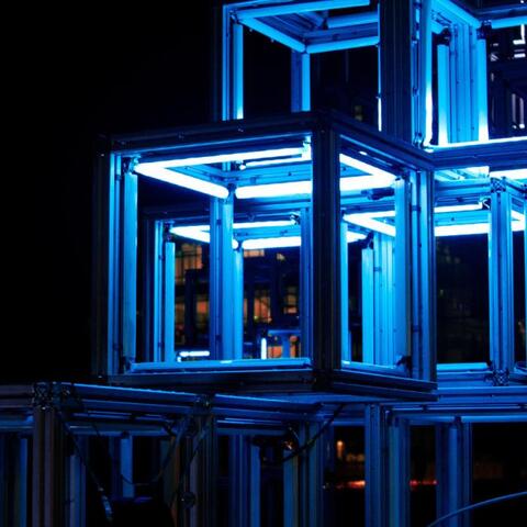 A series of lit up bokes that are implied to either be art or storage spaces for art